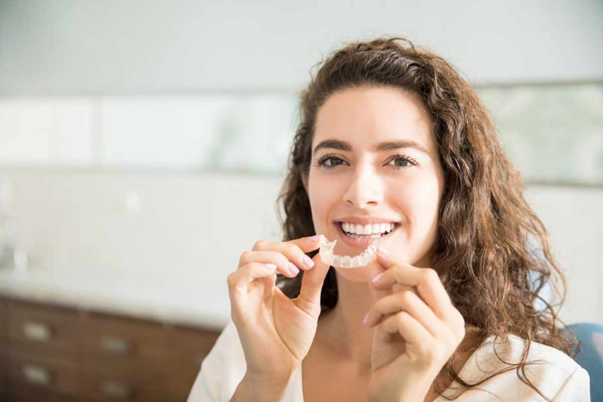 patient holding her new Invisalign braces she got from Stonebriar Family Dentistry in Frisco, TX
